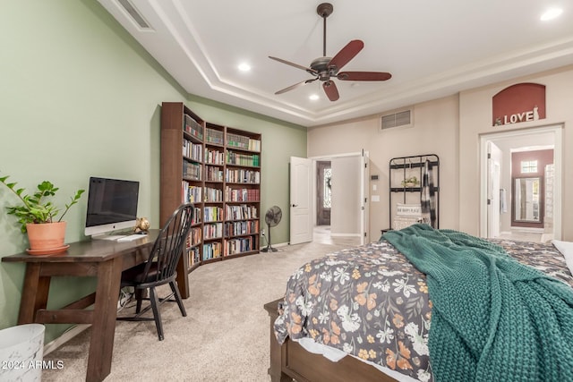 carpeted bedroom with a tray ceiling and ceiling fan