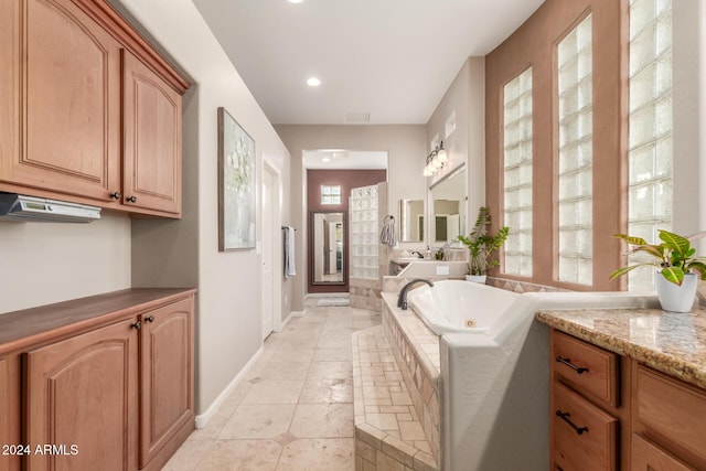 bathroom with tiled bath and vanity