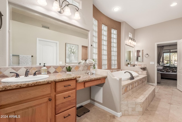 bathroom featuring tile patterned flooring, vanity, tasteful backsplash, and tiled bath