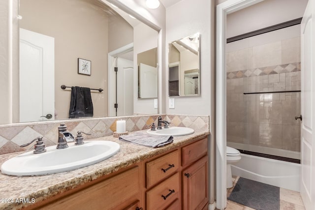 full bathroom with backsplash, vanity, enclosed tub / shower combo, and toilet