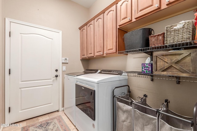 washroom featuring cabinets and washing machine and clothes dryer