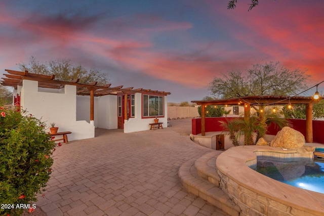 pool at dusk with a patio area