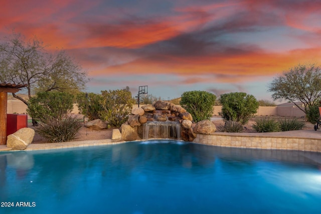 pool at dusk with pool water feature