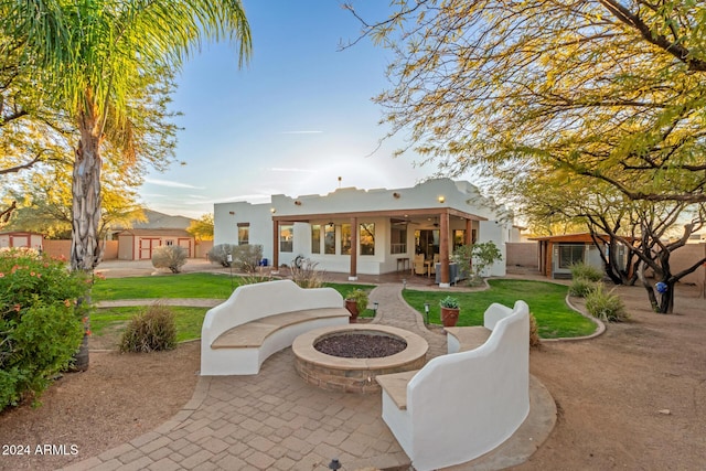 back of house featuring a lawn, ceiling fan, a patio, and an outdoor fire pit