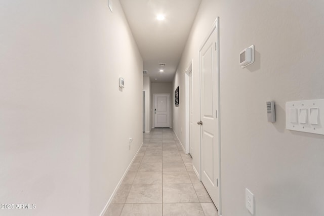 hallway with light tile patterned flooring and baseboards