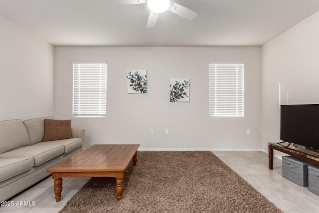 living room featuring light tile patterned floors, baseboards, and a ceiling fan