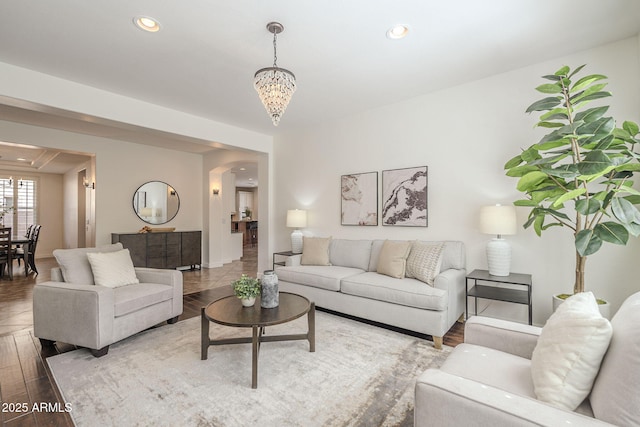 living room featuring arched walkways, a notable chandelier, recessed lighting, and wood finished floors