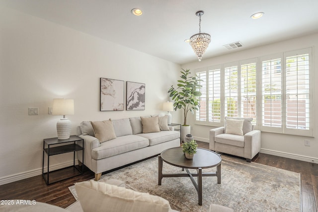 living area featuring wood finished floors, visible vents, baseboards, recessed lighting, and a notable chandelier