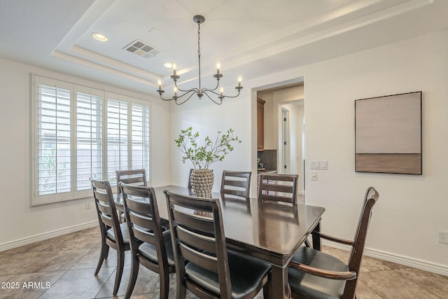 dining room with a chandelier, visible vents, a raised ceiling, and baseboards