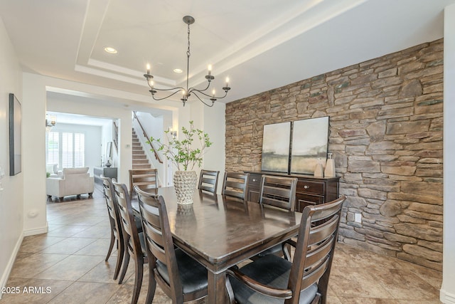 dining area featuring baseboards, stairs, tile patterned floors, a notable chandelier, and a raised ceiling