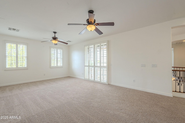 spare room featuring visible vents, light colored carpet, and a ceiling fan