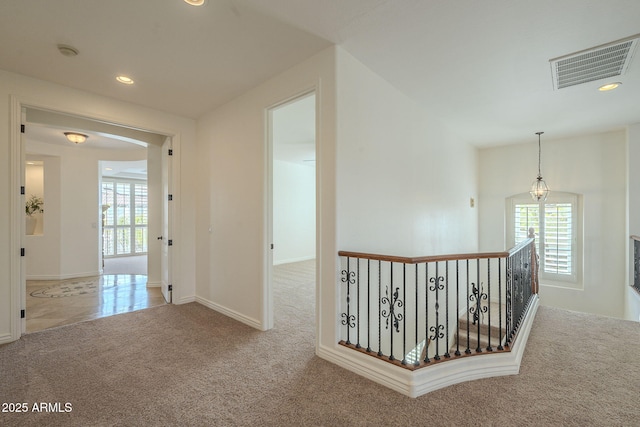 hall with carpet flooring, recessed lighting, visible vents, and a wealth of natural light