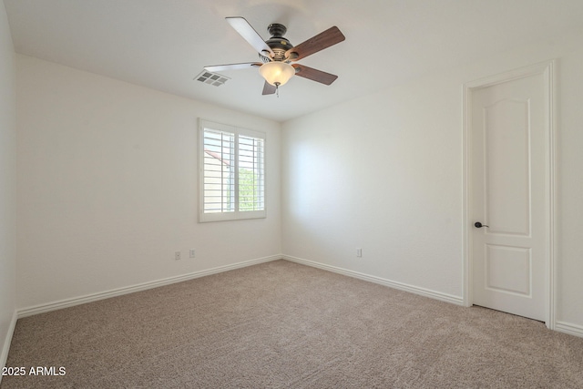 carpeted empty room with visible vents, baseboards, and ceiling fan