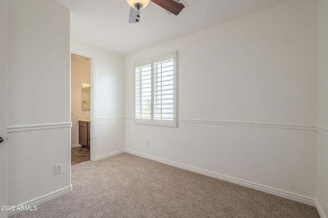 unfurnished bedroom with carpet flooring, connected bathroom, a ceiling fan, and baseboards