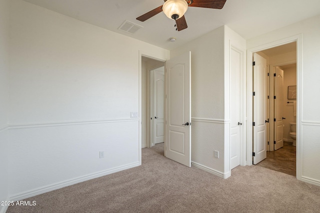 unfurnished bedroom featuring visible vents, baseboards, carpet, and a ceiling fan