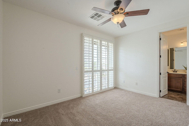 unfurnished bedroom with a sink, visible vents, baseboards, and carpet