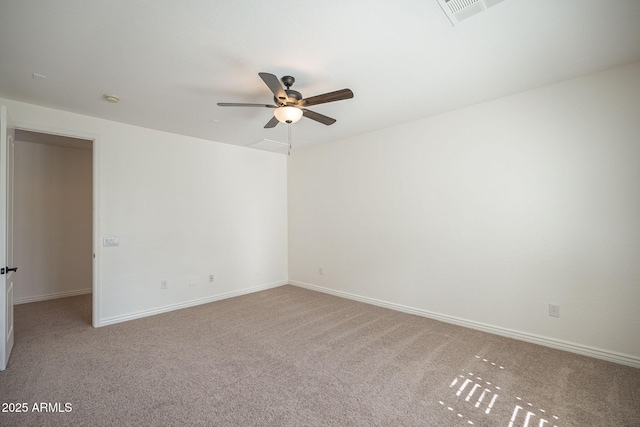 carpeted spare room featuring visible vents, baseboards, and a ceiling fan