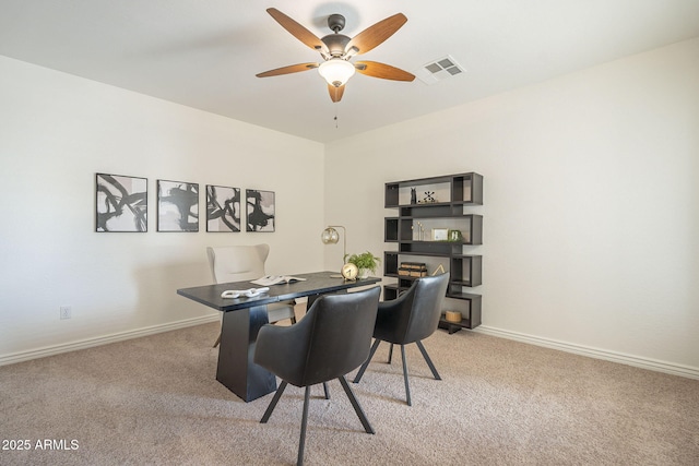 office area with visible vents, light colored carpet, baseboards, and a ceiling fan