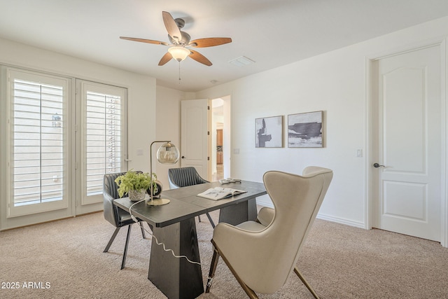 home office with baseboards, a ceiling fan, visible vents, and light carpet