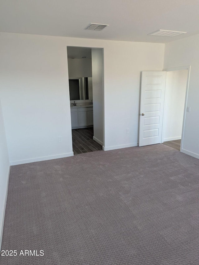 empty room featuring dark colored carpet and sink