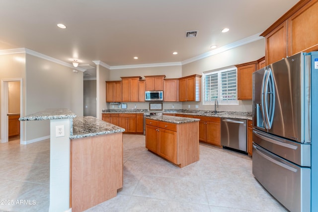 7969 S 172nd St, Queen Creek, AZ 85142 - kitchen featuring stainless steel appliances, a center island, brown cabinets, crown molding, and a sink