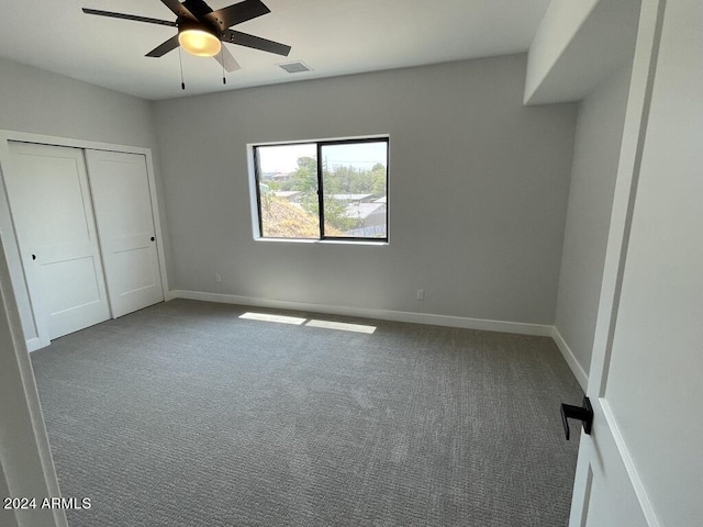 unfurnished bedroom featuring carpet floors, a closet, and ceiling fan