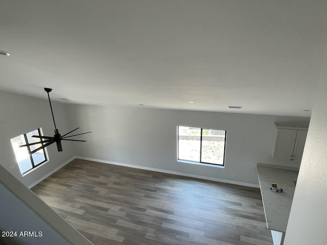 unfurnished living room featuring vaulted ceiling, dark hardwood / wood-style floors, and ceiling fan