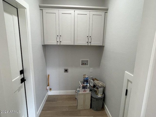 laundry room featuring electric dryer hookup, hookup for a washing machine, cabinets, and hardwood / wood-style flooring