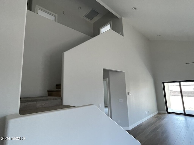 interior space with a high ceiling and dark hardwood / wood-style flooring