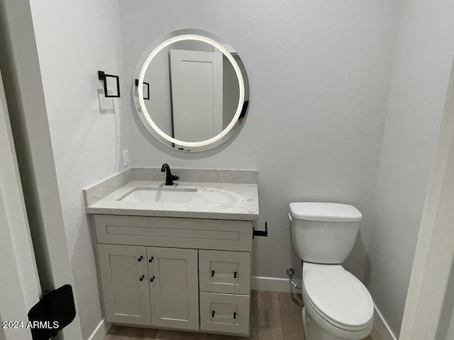 bathroom with vanity, wood-type flooring, and toilet