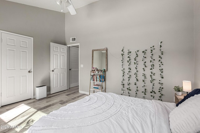 520 N Stapley Dr Unit 286, Mesa, AZ 85203 - bedroom featuring light wood-type flooring, visible vents, baseboards, and a high ceiling