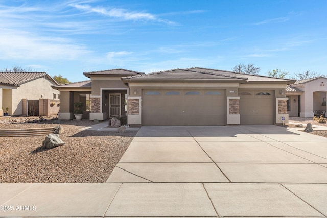 prairie-style home with stone siding, an attached garage, driveway, and stucco siding