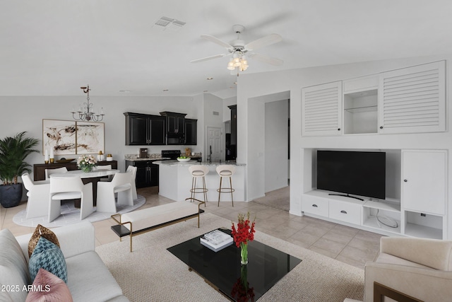 living room featuring ceiling fan, visible vents, vaulted ceiling, and light tile patterned flooring