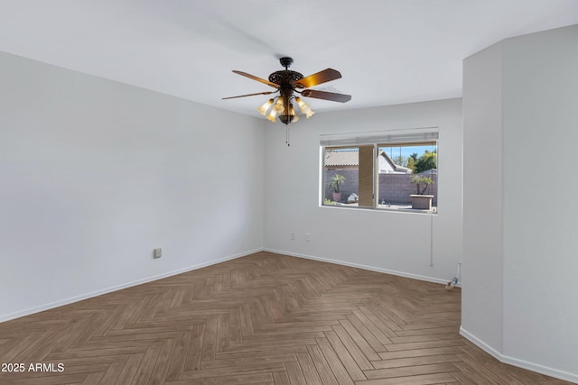 spare room featuring ceiling fan and baseboards