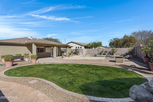 rear view of property with a lawn, a fenced in pool, a fenced backyard, a patio area, and stucco siding