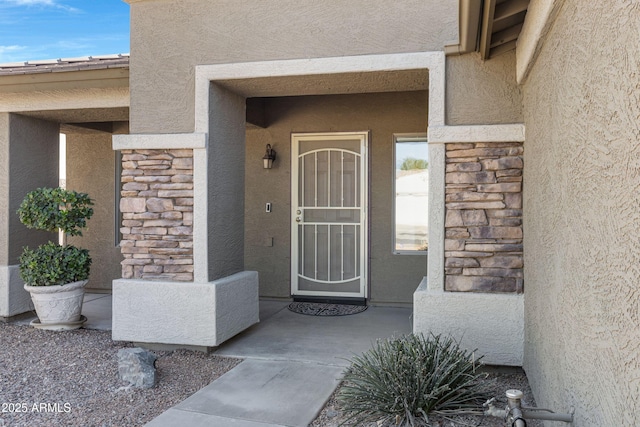 property entrance with stone siding and stucco siding