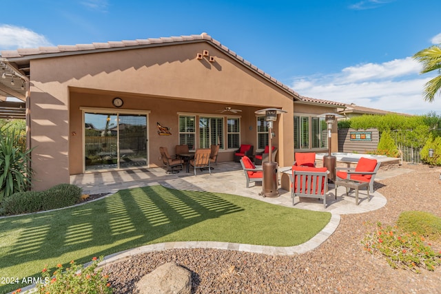 rear view of house featuring a yard, a patio area, and ceiling fan