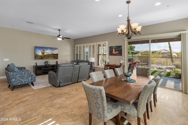 dining area featuring ceiling fan with notable chandelier