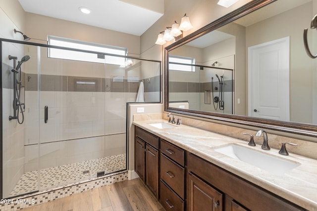 bathroom with vanity, a shower with shower door, and wood-type flooring