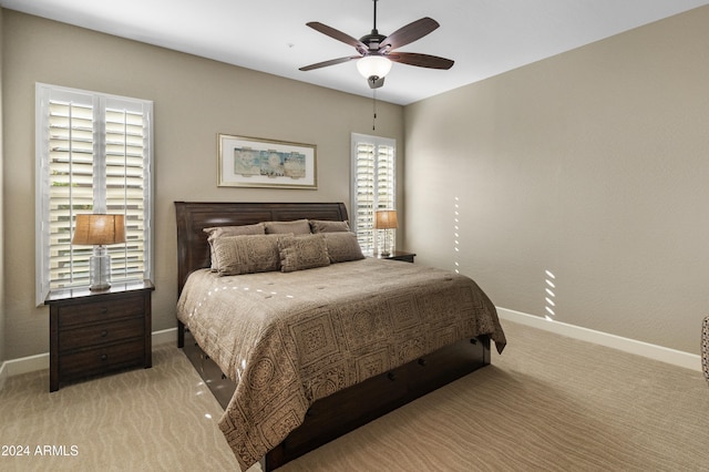 bedroom with multiple windows, light colored carpet, and ceiling fan