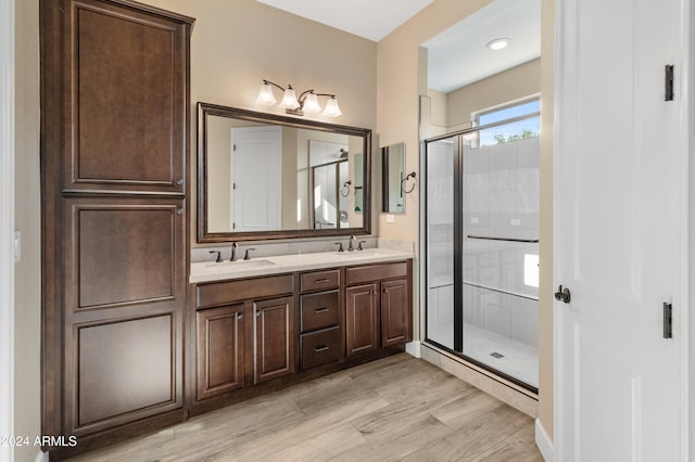 bathroom featuring vanity, a shower with shower door, and wood-type flooring