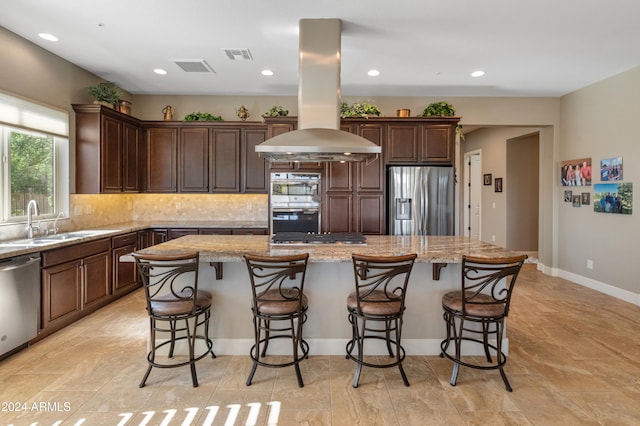 kitchen with island exhaust hood, stainless steel appliances, sink, and a kitchen island