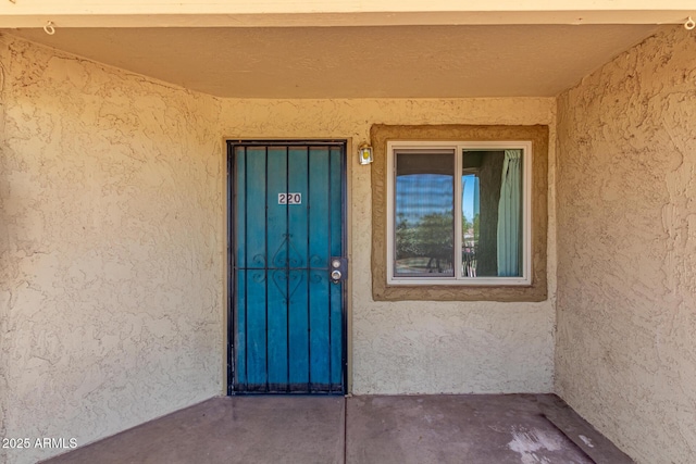 property entrance with stucco siding