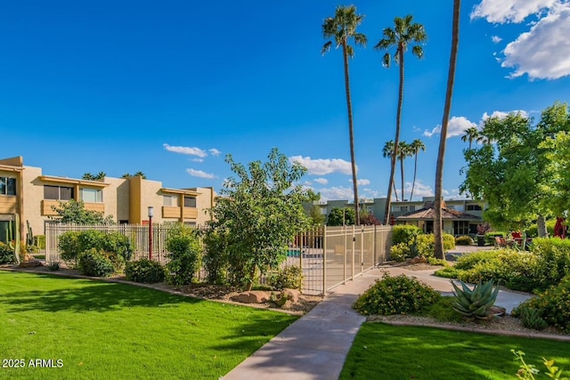 view of home's community featuring a lawn, fence, and a residential view