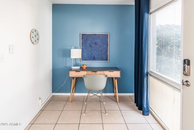 unfurnished office featuring baseboards and tile patterned floors