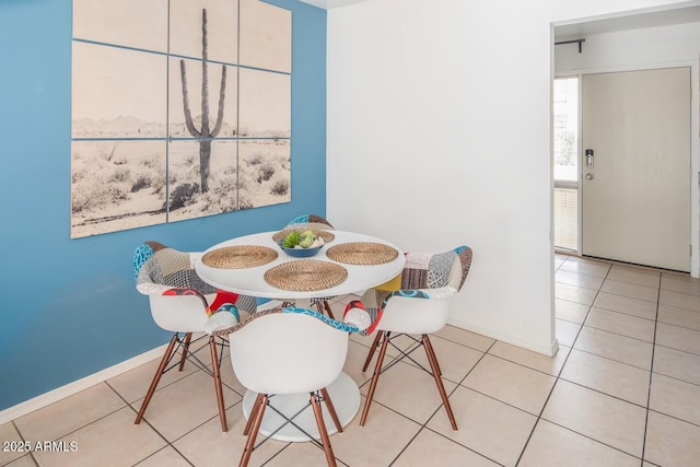 tiled dining space featuring baseboards