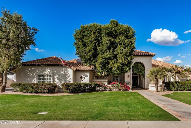 mediterranean / spanish home with a front yard