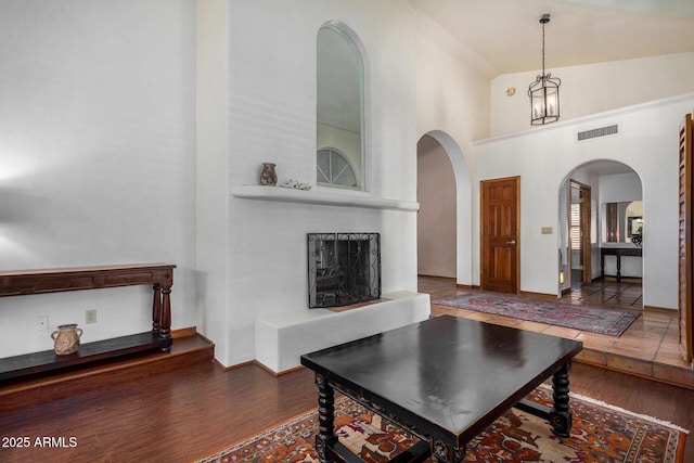 living room with dark hardwood / wood-style floors and high vaulted ceiling