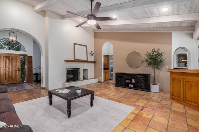 living room with beamed ceiling, light tile patterned flooring, wooden ceiling, and ceiling fan