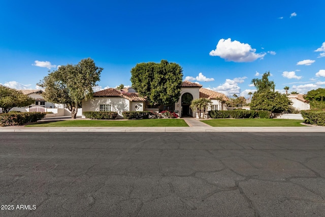 mediterranean / spanish-style house with a front yard